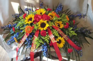 Casket Spray with Delphinium, Sunflowers, Carnations, Large Gerbera Daisy and Solidaster
