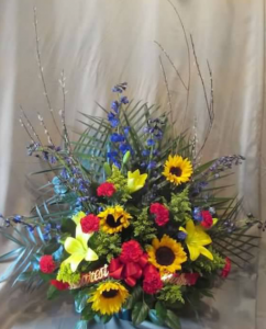 Traditional Tribute with Delphinium, Asiatic Lily, Sunflowers, Carnations, and Solidaster with Branch Accents