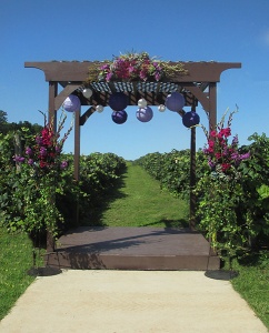 Gazebo with Purple Floral Swag and Ivy Draped Pedestals