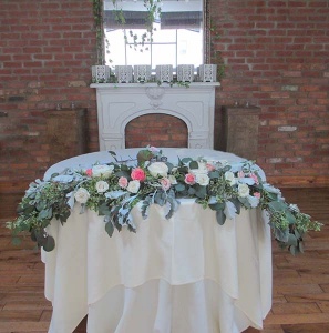 Head Table Arrangement with Pink and Ivory Roses, Eucalyptus, and Dusty Miller